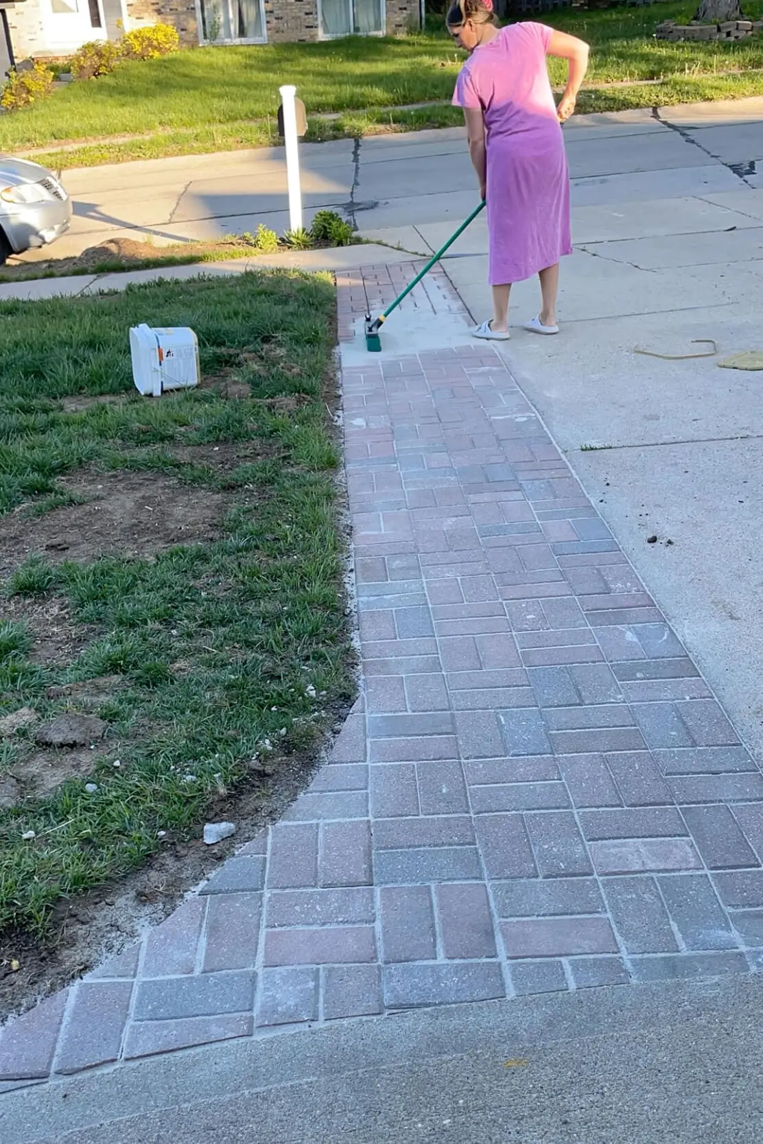 Using polymer sand to finish a paver driveway extension.